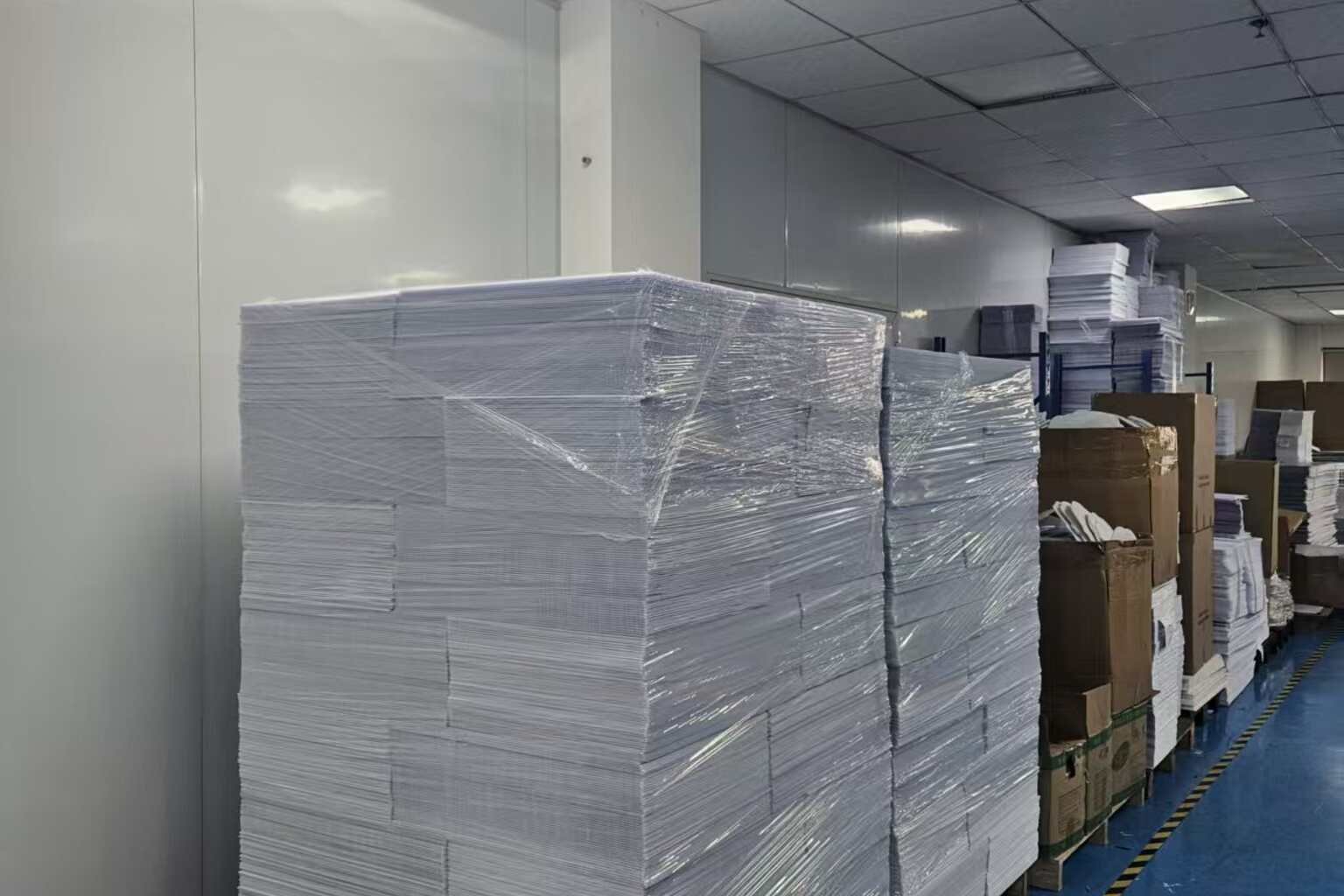 Warehouse pallets stacked with bulk corrugated plastic yard signs for inventory and reorder planning