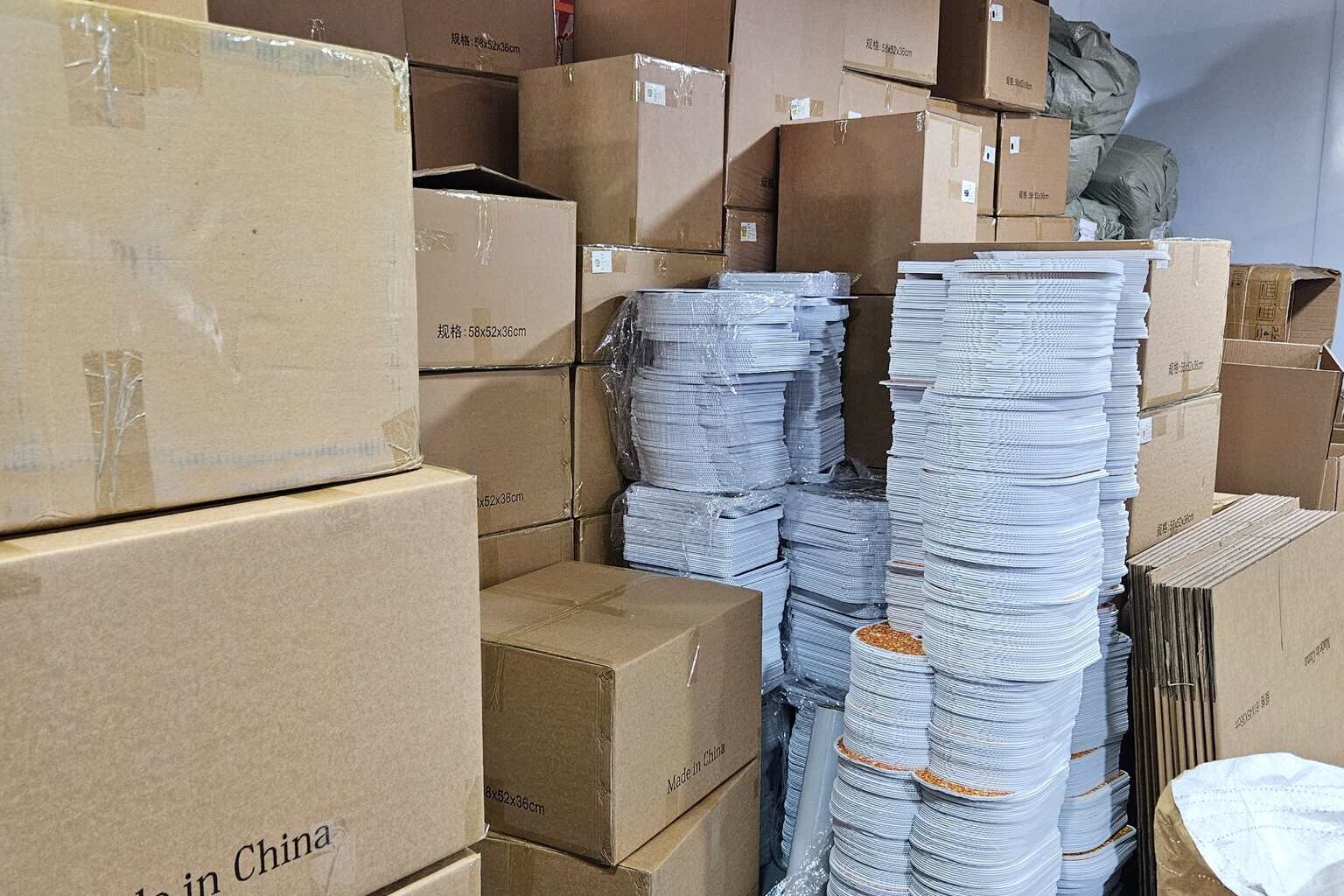 Warehouse with bulk corrugated plastic yard signs, cartons, and packaging materials prepared for a purchase order