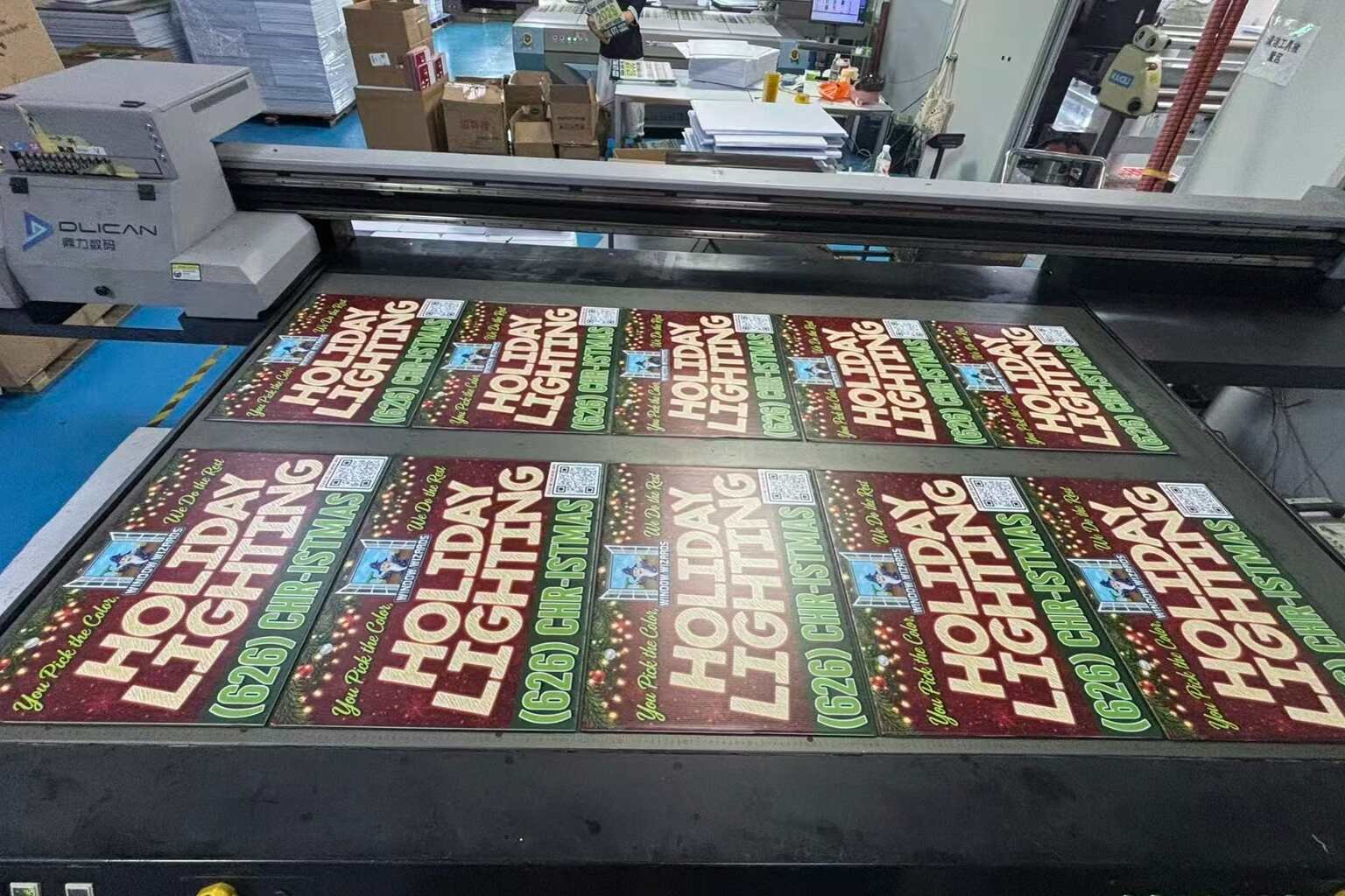 Warehouse manager calculating the landed cost of bulk yard signs with cartons, H-stakes, shipping documents, and printed signs
